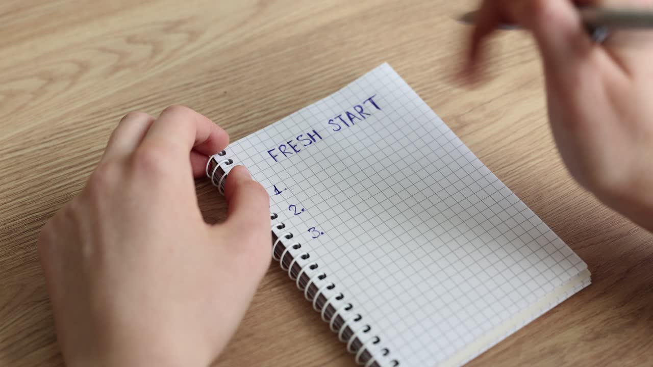 Nervøs mann prøver å lage en 'ny start'-liste ved et trebord.