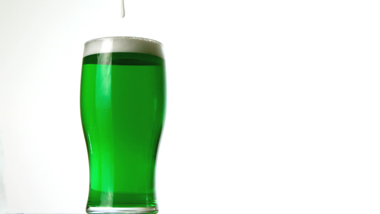 espuma vertiendo en una pinta de cerveza verde