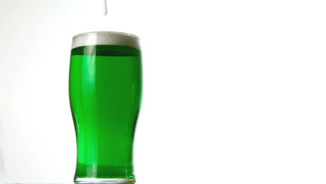 Foam-pouring-onto-pint-of-green-beer