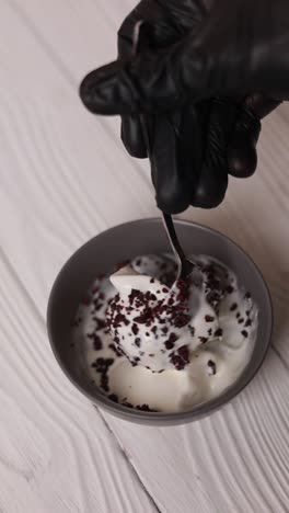 preparing a dessert with ice cream and toppings