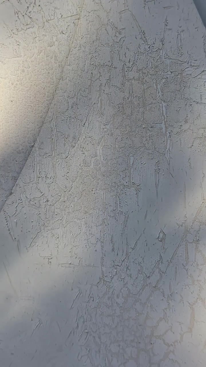 Rough plastered wall texture with dramatic diagonal shadow