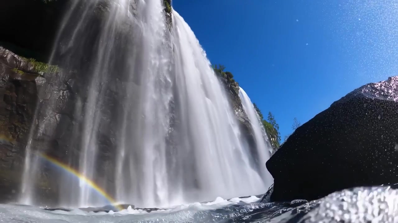 Vista em ângulo baixo de uma majestosa cachoeira com arco-íris