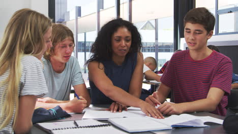 Lehrer-Studiert-Schulbücher-Im-Unterricht-Mit-High-School-Kindern