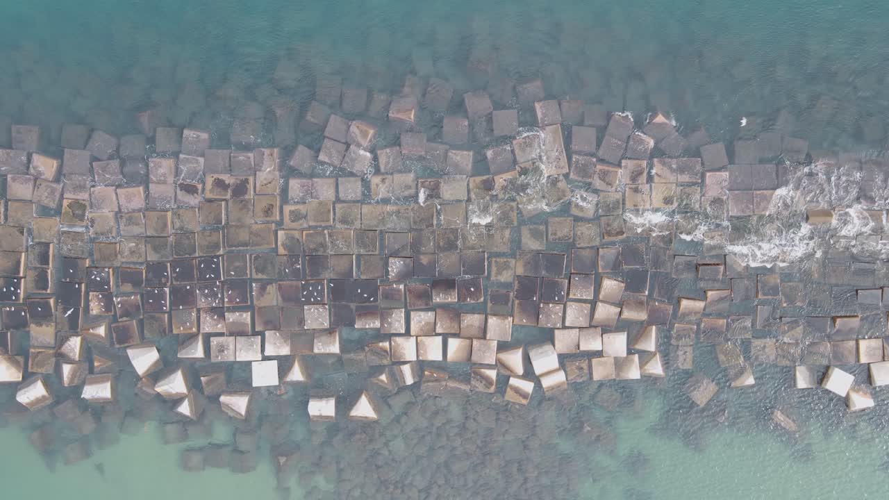 vista de arriba hacia abajo del rompeolas sobre el mar