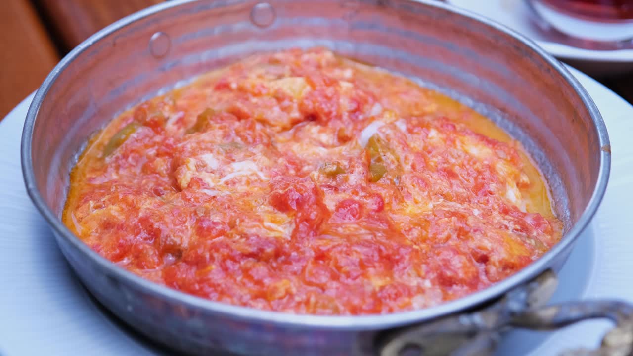 el plato tradicional turco es el menemen. el hombre hambriento come el menemen para el desayuno.