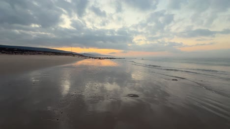 In-the-evening,-sea-waves-gently-splash-onto-the-sandy-shores-of-coastal-Spain,-capturing-the-serene-beauty-and-tranquility-of-the-seaside