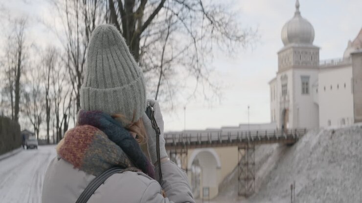 Femme photographiant un château en hiver