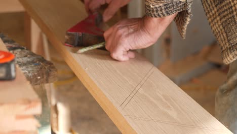 skilled shipwright tracing seat knees on oak wood in a traditional vessel build