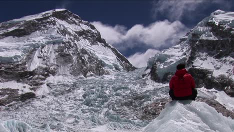 escalador sentado mirando la cascada de hielo de khumbu
