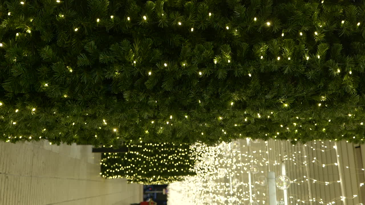 Glowing ceilings and walls with Christmas lights in shopping mall, vertical view