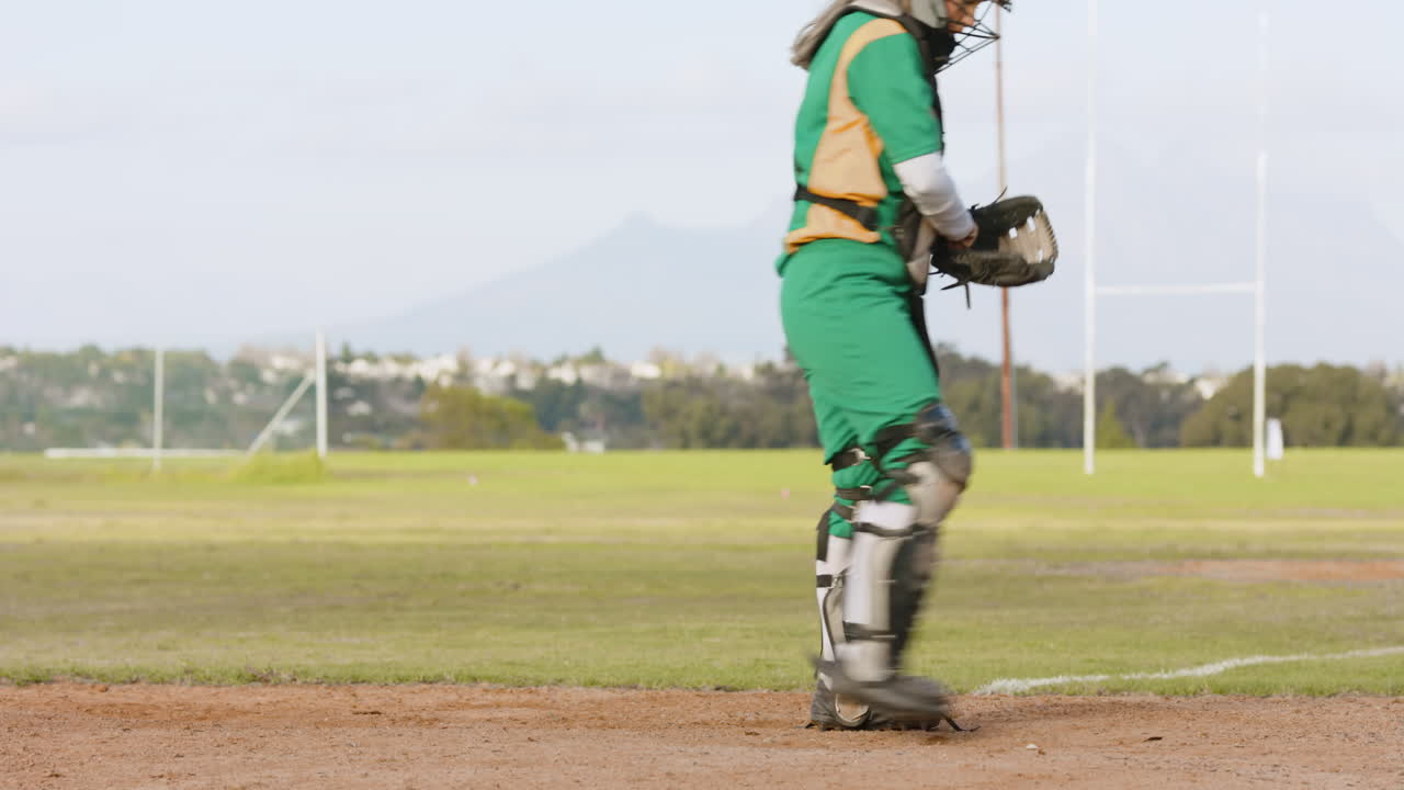Giocatrice di baseball con uniforme verde, che prende e lancia la palla su un campo da gioco, con spazio per il testo.