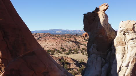 drone flies between rocks in a desert and rocky landscape