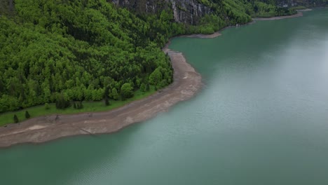 Wunderschöne-Luftaufnahme-Des-Mit-Wald-Geschmückten-Ufers-Des-Klöntalersees