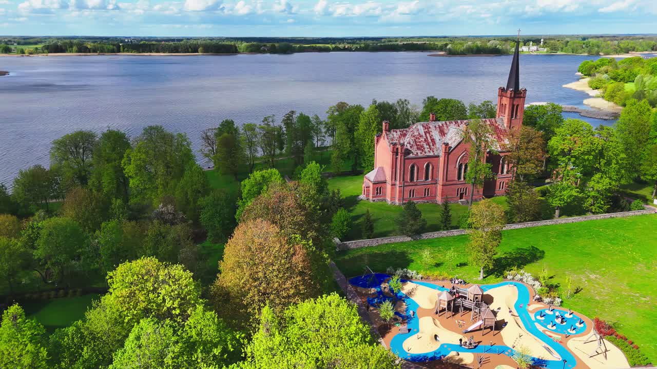 Evangelical Reformed Church And Vaikų žaidimų aikštelė Playground In Birzai, Lithuania. Aerial Drone Shot