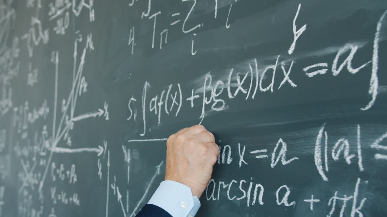 Person writing equations on a chalkboard