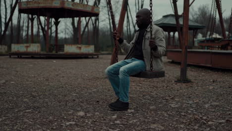 man on a swing in an abandoned park