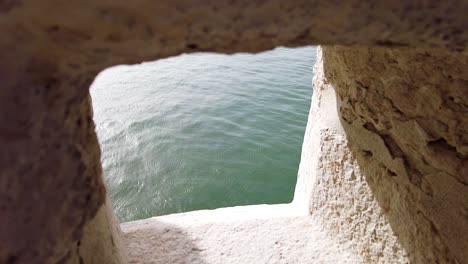 a tower hole towards tagus river in belem tower, lisbon, portugal