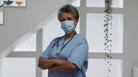 retrato de una mujer médica afroamericana mayor con una máscara facial mirando a la cámara