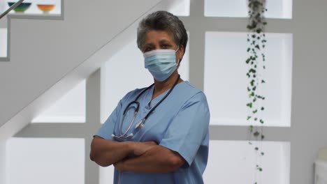 portrait of senior african american female doctor wearing face mask looking at camera