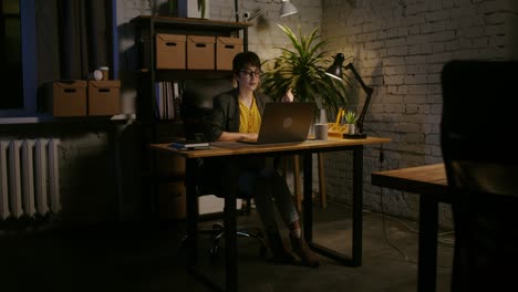 mujer trabajando hasta tarde en la noche en la computadora portátil en la oficina de casa