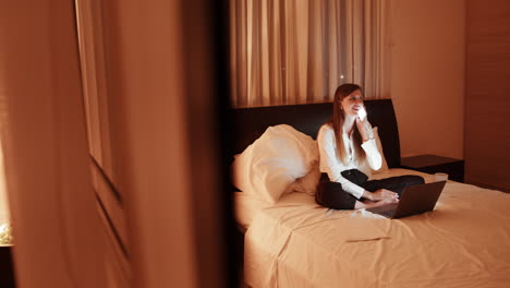 woman working from bed at night