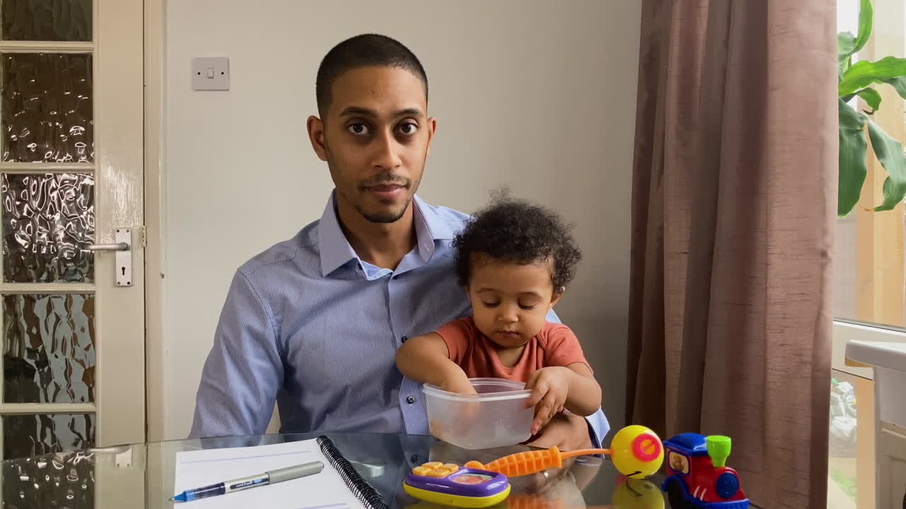 Young Man with Small Child On Business Video Call Waiting for Meeting to Begin