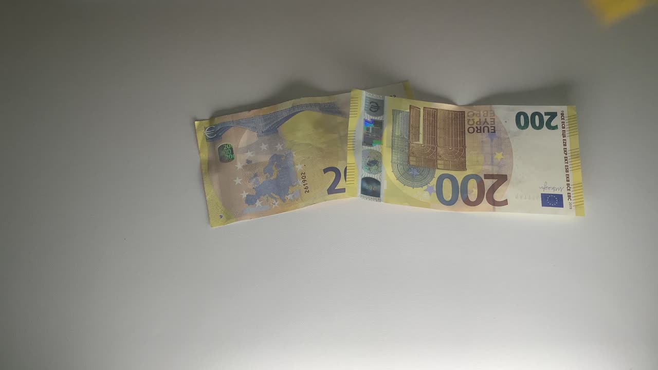 Flyvende 200 eurosedler på et hvitt bord