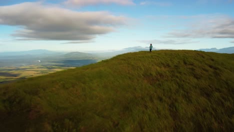 drone-shot-of-a-woman-walking-on-top-of-a-hill