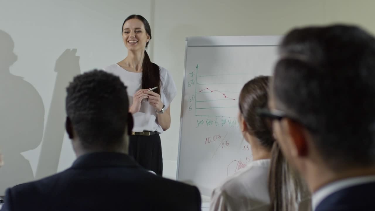 una mujer de negocios riendo entregando un informe a la audiencia.