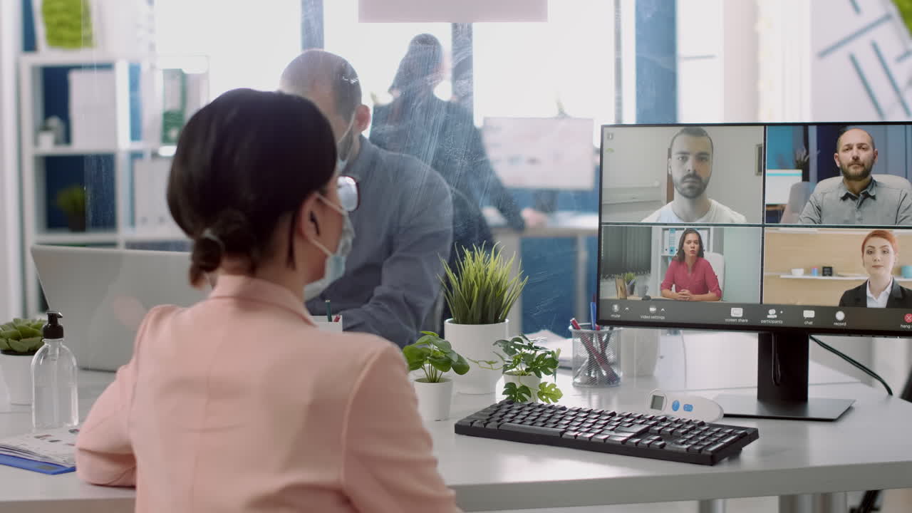 Businesswoman having online videocall conference wearing medical face mask