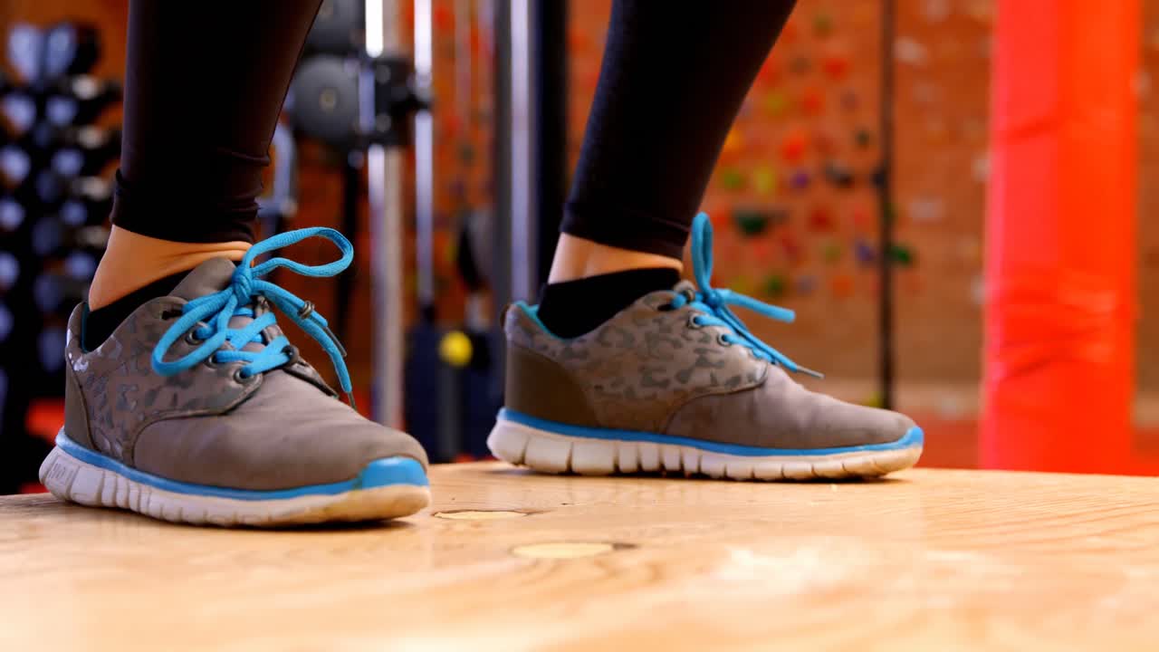 피트니스 스튜디오 4k에서 점프 스 ⁇ 을 하는 결단력 있는 백인 여성