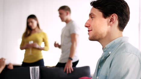 young man talking at a party in a loft apartment, close up