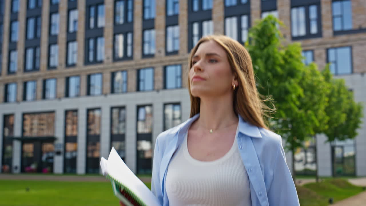 Lady checking smartphone walking street with documents feeling stress closeup