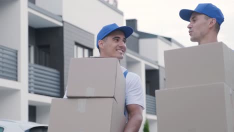 two young workers of removal company deliver boxes to a customer's home