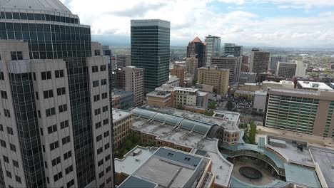 a drone captures aerial footage of downtown salt lake city buildings and skyscrapers flying southeast over the city