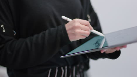 close up hands young engineers developing bicycle prototype using tablet computer viewing 3d design on touchscreen device brainstorming future development collaborating in creative office