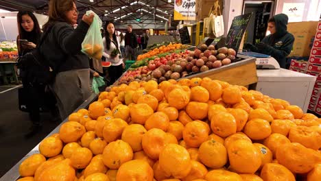 woman selecting oranges at a fruit stall