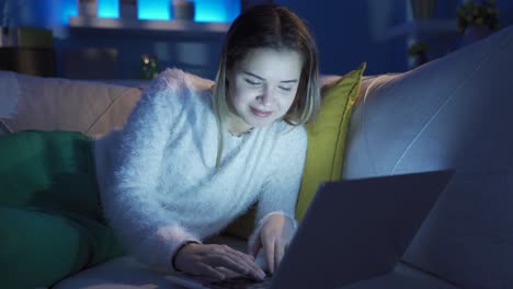 young woman chatting on laptop is laughing and happy.