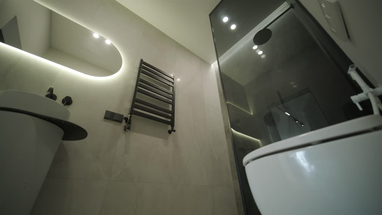 벽에 장착된 화장실과 회색 타일 디자인의 현대적인 욕실