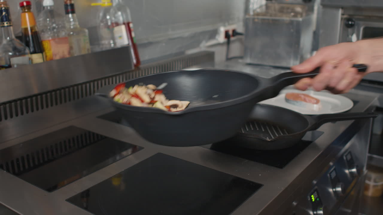 Hand Tossing Vegetables In Wok Pan