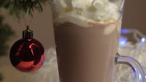 verter crema batida sobre una bebida de chocolate caliente en navidad