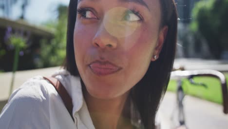 mujer afroamericana comiendo ensalada sentada en un parque de la ciudad