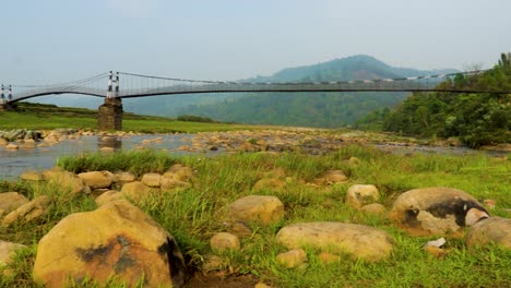 puente colgante de hierro aislado sobre el río que fluye con fondo de montaña y cielo azul en el video de la mañana se toma en nongjrong meghalaya india