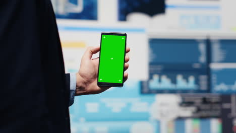 Male administrator uses green screen phone to explore new growth strategy