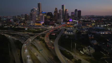 Vista-Aérea-Hacia-El-Horizonte-Iluminado-De-La-Ciudad-De-Houston,-Atardecer-En-Texas,-Estados-Unidos