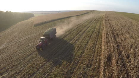 Loaded-with-crops-tractor-driving-on-field-aerial-view