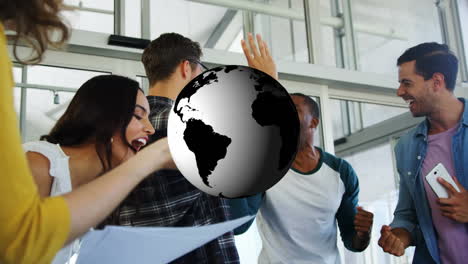 animation of rotating globe over happy diverse colleagues celebrating at casual office meeting