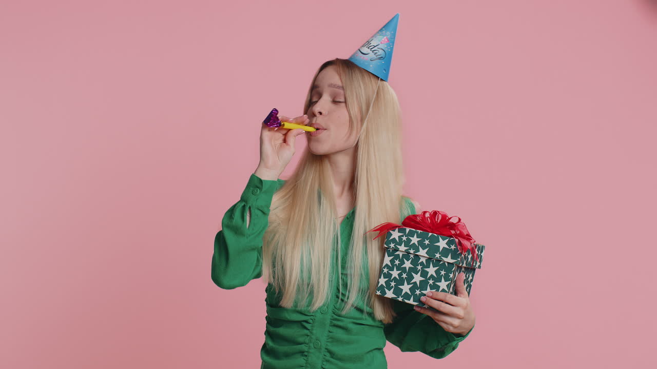 Happy excited lucky woman wearing birthday hat cone blow pipe celebrating party success win victory