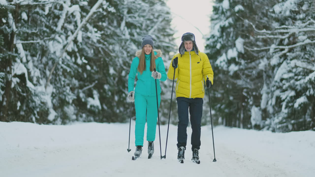 Slow motion shot of a loving couple skiing in the woods on the eve of Valentine's day