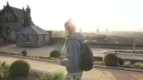 tracking, follow shot of a girl walking on top or calton hill in edinburgh scotland during sunset